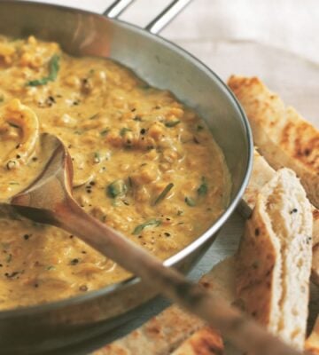 an example of high protein vegan recipes to make for Veganuary, a pan of coconut dhal with toasted naan fingers on the side