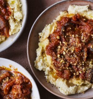 three bowls of vegan pulled aubergine ragu on top of hummus infused mash