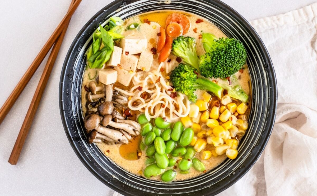 a bowl of quick vegan ramen with mushrooms, tofu, edamame, broccoli, and corn