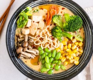 a bowl of quick vegan ramen with mushrooms, tofu, edamame, broccoli, and corn