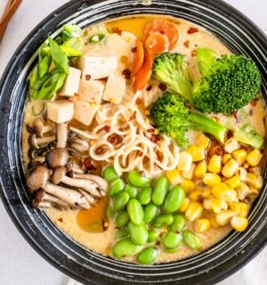 a bowl of quick vegan ramen with mushrooms, tofu, edamame, broccoli, and corn