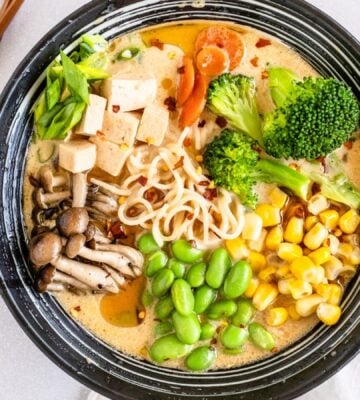 a bowl of quick vegan ramen with mushrooms, tofu, edamame, broccoli, and corn