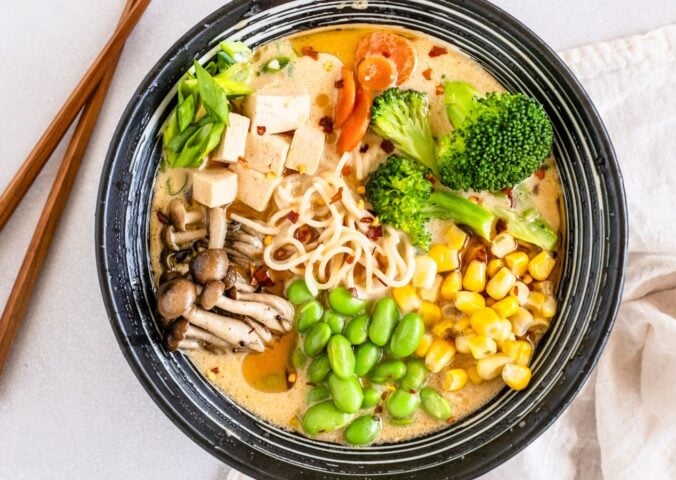 a bowl of quick vegan ramen with mushrooms, tofu, edamame, broccoli, and corn