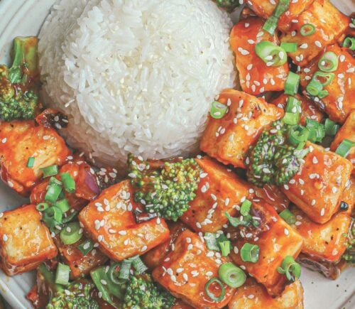 a plate of rice and spicy sweet & sour tofu broccoli stir fry