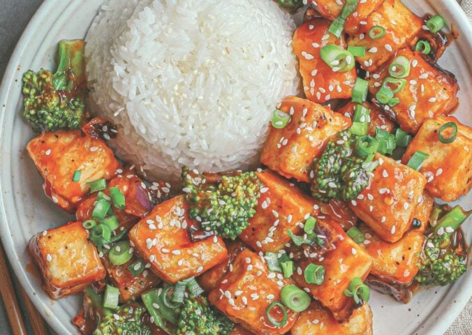 a plate of rice and spicy sweet & sour tofu broccoli stir fry