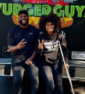 Photo shows Tabitha Brown and Vurger Guyz founder Na’eem Outler sat on the back of the Vurger Guyz food truck