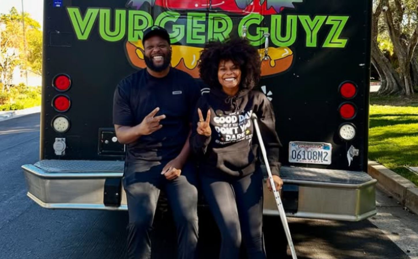 Photo shows Tabitha Brown and Vurger Guyz founder Na’eem Outler sat on the back of the Vurger Guyz food truck