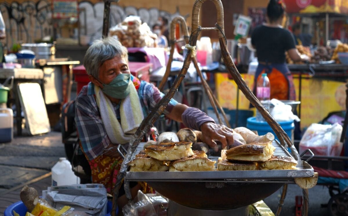 Photo shows a street food vendor cooking in Thailand