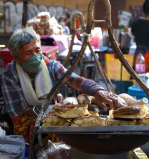 Photo shows a street food vendor cooking in Thailand