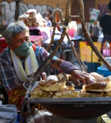 Photo shows a street food vendor cooking in Thailand