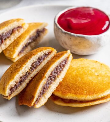 a plate of vegan dorayaki pancakes with raspberry sauce