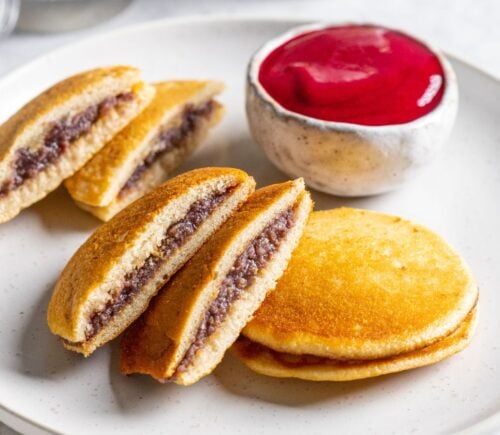 a plate of vegan dorayaki pancakes with raspberry sauce