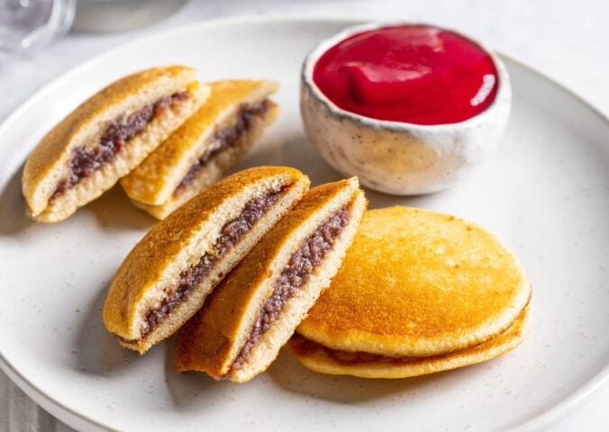 a plate of vegan dorayaki pancakes with raspberry sauce