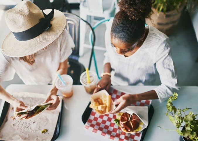 Two women eating vegan food in a vegan restaurant