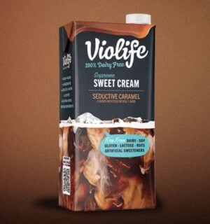 A carton of Violife lentil coffee creamer in front of a brown background