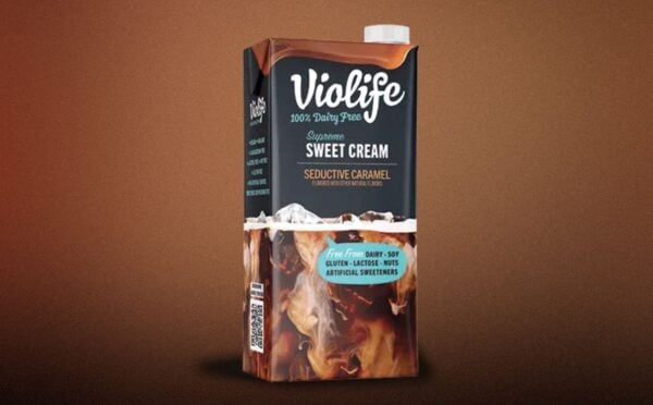 A carton of Violife lentil coffee creamer in front of a brown background