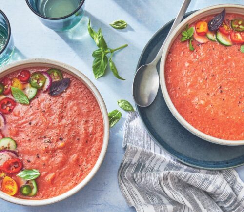two bowls of watermelon gazpacho made with watermelon, tomato, cucumber, and herbs