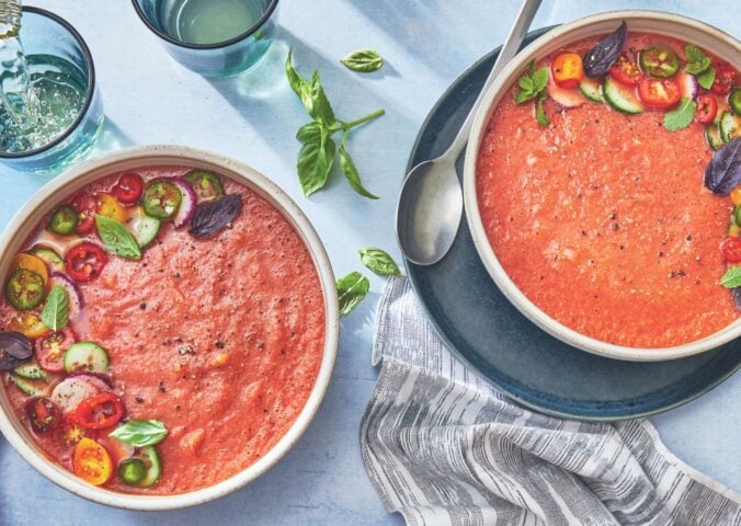 two bowls of watermelon gazpacho made with watermelon, tomato, cucumber, and herbs