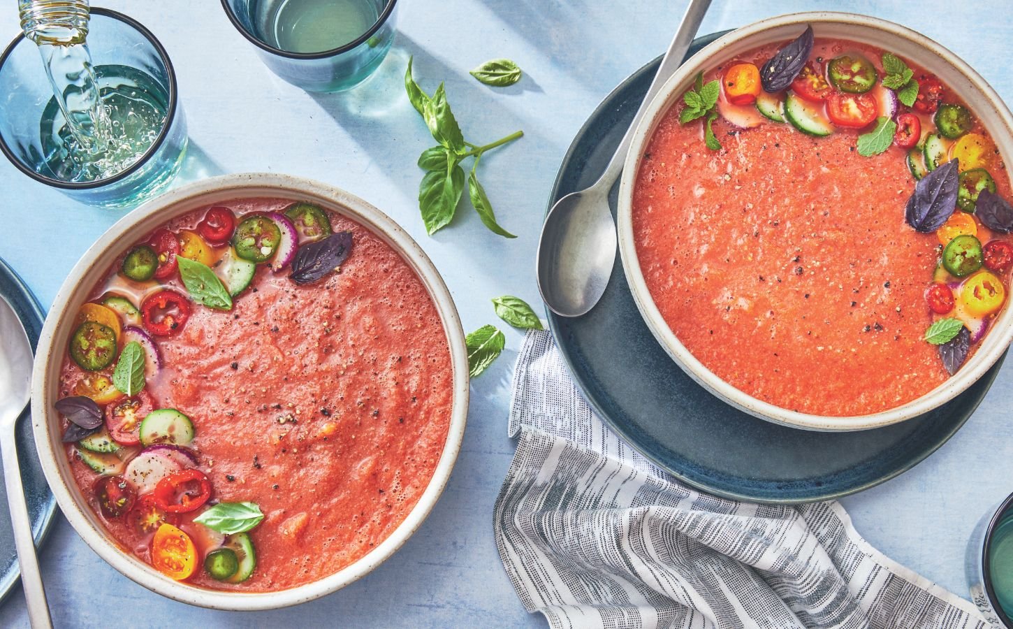 two bowls of watermelon gazpacho made with watermelon, tomato, cucumber, and herbs