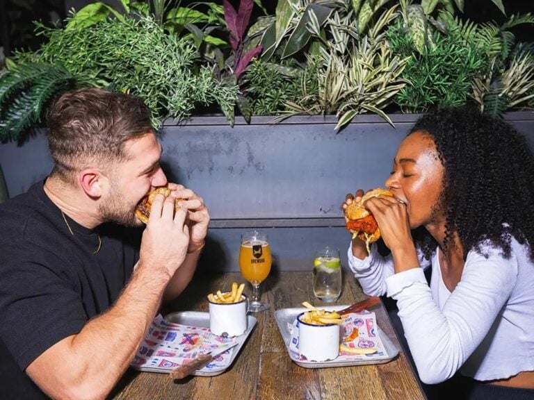 Two Brewdog customers eating vegan burgers off the plant-based menu