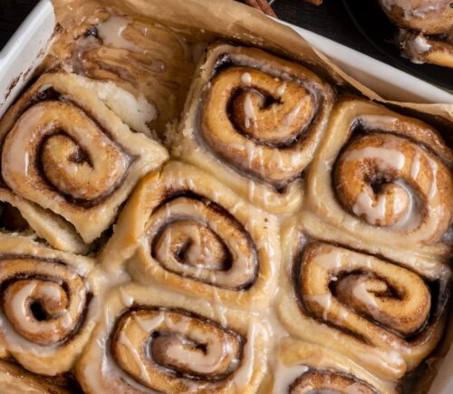 a baking dish full of vegan chai spiced cinnamon rolls