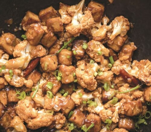 a wok full of vegan chili cauliflower and tofu