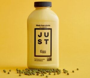 A bottle of Just Egg in front of a yellow background, a plant-based egg alternative