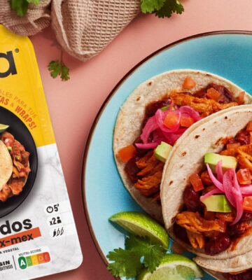 A packet of Heura Foods Tex-Mex chunks next to a some vegan tacos made with the chunks