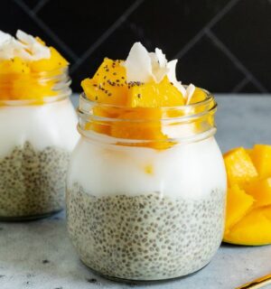 two jars of mango coconut chia seed pudding with sliced mango and coconut