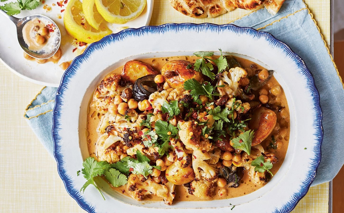 a dish of oven-baked butter chickpeas with chutney, cauliflower, potatoes, and curry spices