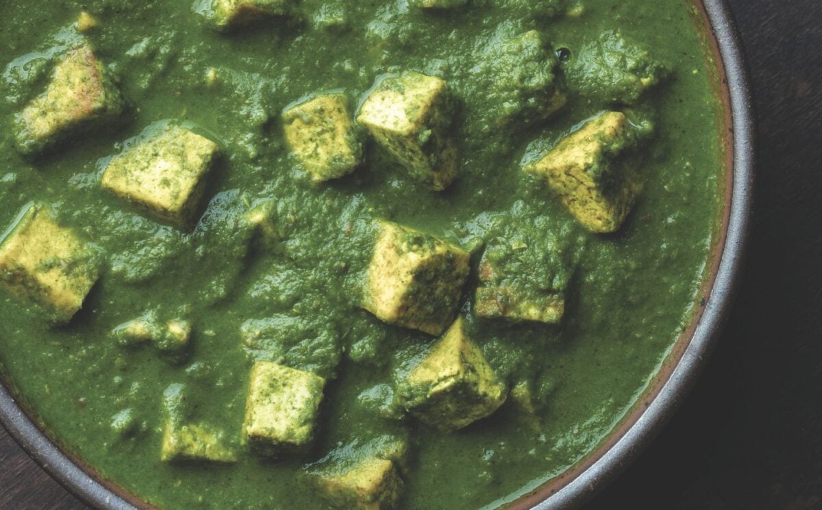 a bowl of Pālak tofu with spinach gravy with turmeric tofu