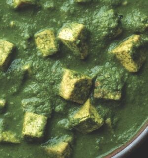 a bowl of Pālak tofu with spinach gravy with turmeric tofu