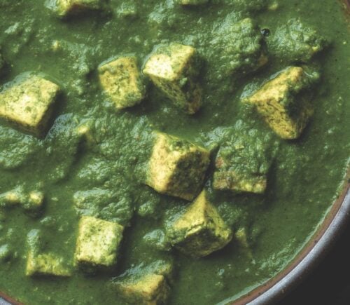 a bowl of Pālak tofu with spinach gravy with turmeric tofu