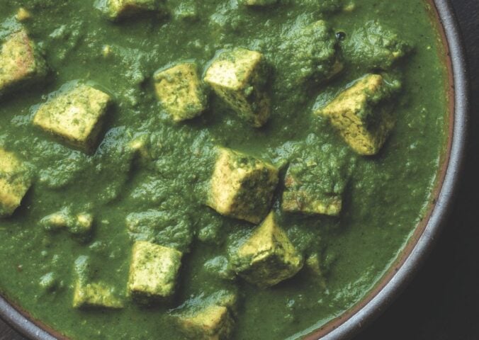 a bowl of Pālak tofu with spinach gravy with turmeric tofu