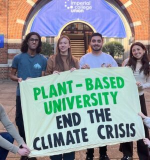 Students at Imperial College London holding up a sign saying "Plant-Based University End The Climate Crisis"