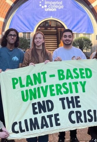 Students at Imperial College London holding up a sign saying "Plant-Based University End The Climate Crisis"