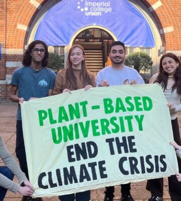 Students at Imperial College London holding up a sign saying "Plant-Based University End The Climate Crisis"