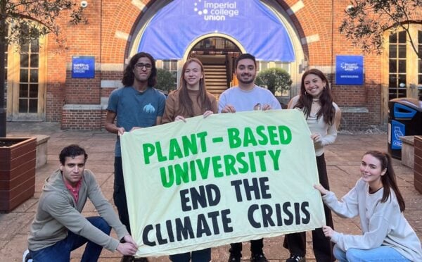 Students at Imperial College London holding up a sign saying "Plant-Based University End The Climate Crisis"