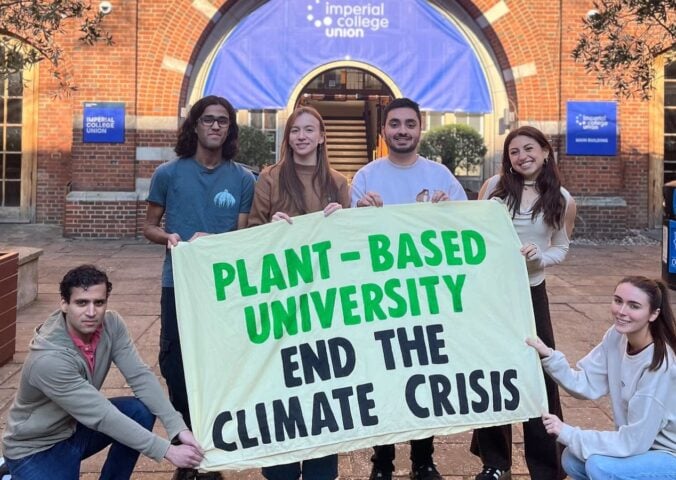 Students at Imperial College London holding up a sign saying "Plant-Based University End The Climate Crisis"