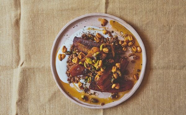 a plate of plantain and brown lentils with hot pistachio and corn nut dressing