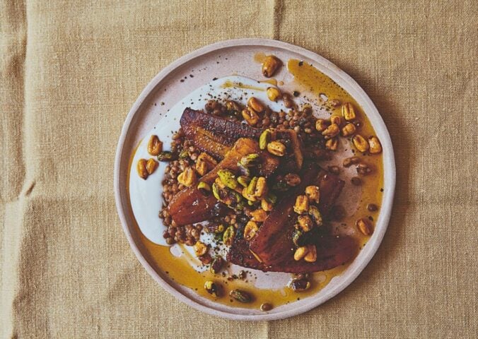 a plate of plantain and brown lentils with hot pistachio and corn nut dressing