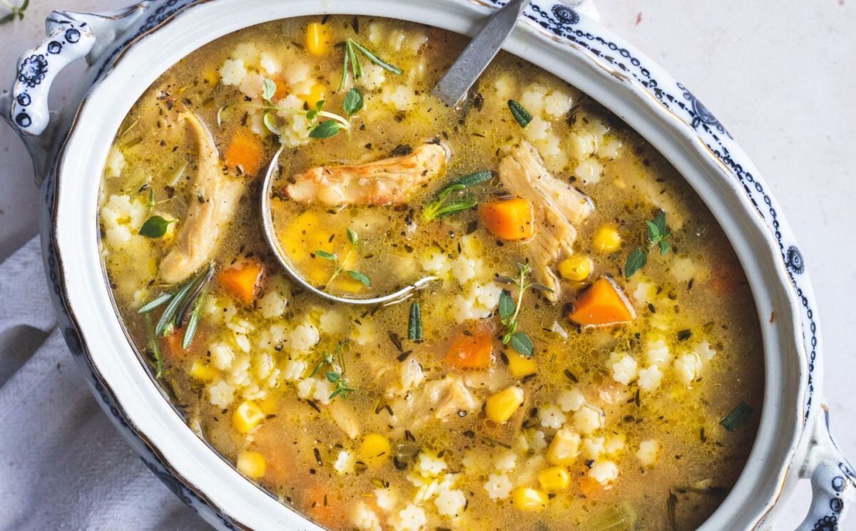 rainy day vegan dinner ideas like vegan chicken noodle soup recipe made with tofu pieces, small soup pasta, vegetables, rosemary, thyme, and lemon