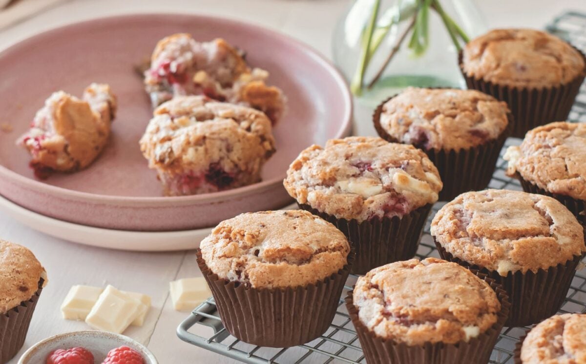 vegan raspberry and white chocolate muffins on a cooling rack in rows