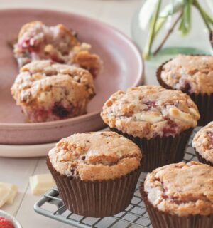 vegan raspberry and white chocolate muffins on a cooling rack in rows