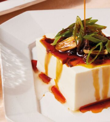 a plate of two-minute tofu with scallions, tamari, sesame oil, and chili crisp