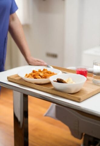 A nurse serving a patient plant-based hospital food