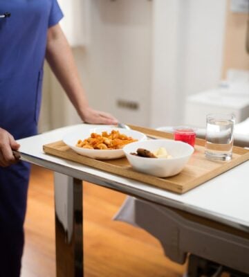 A nurse serving a patient plant-based hospital food