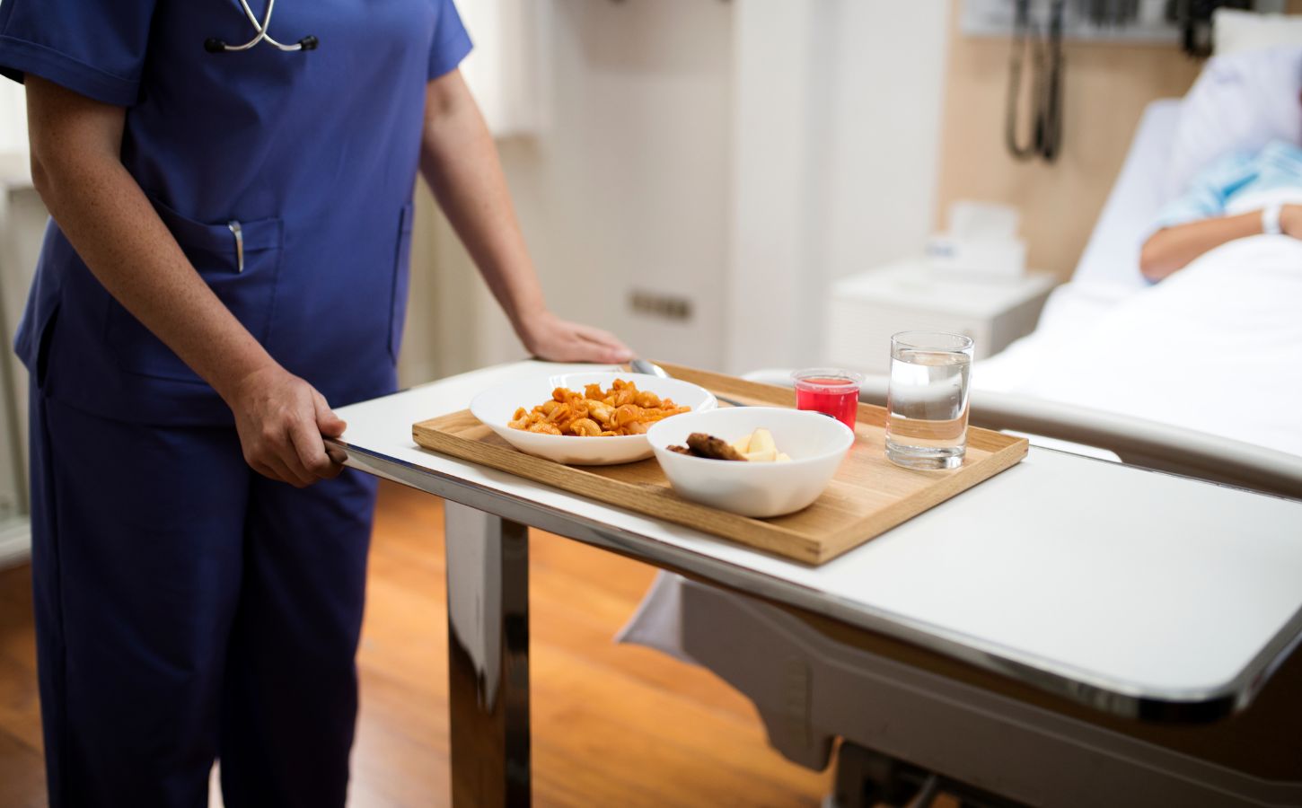 A nurse serving a patient plant-based hospital food