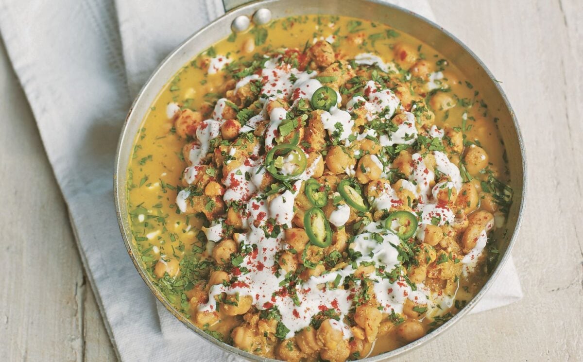 a pan of spicy chickpea curry with soya yogurt, fresh green chili, and chickpeas for spicy vegan dinner recipes