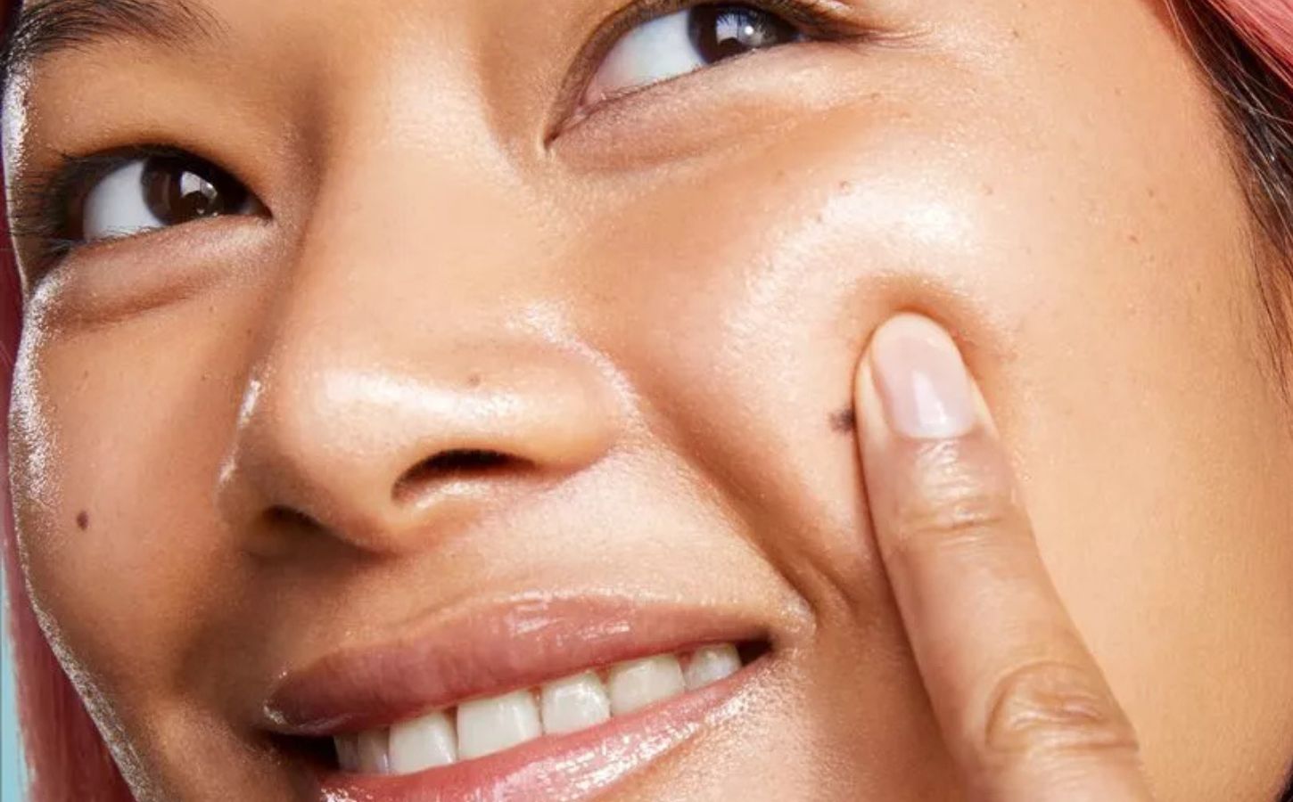 A woman applying vegan glass skin serum in an advert for BYOMA